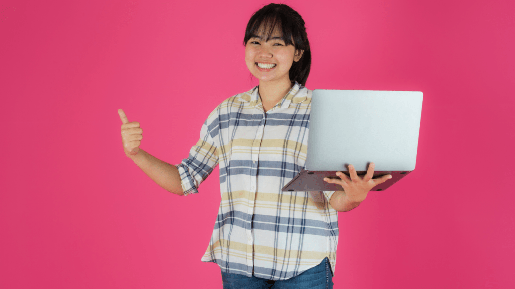 woman holding her laptop in pink background